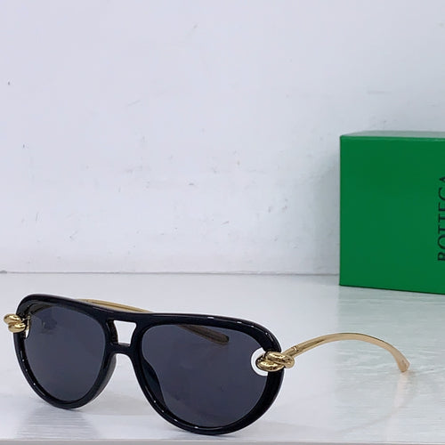 Black sunglasses with dark lenses, gold-tone bridge detail and narrow cat-eye frame