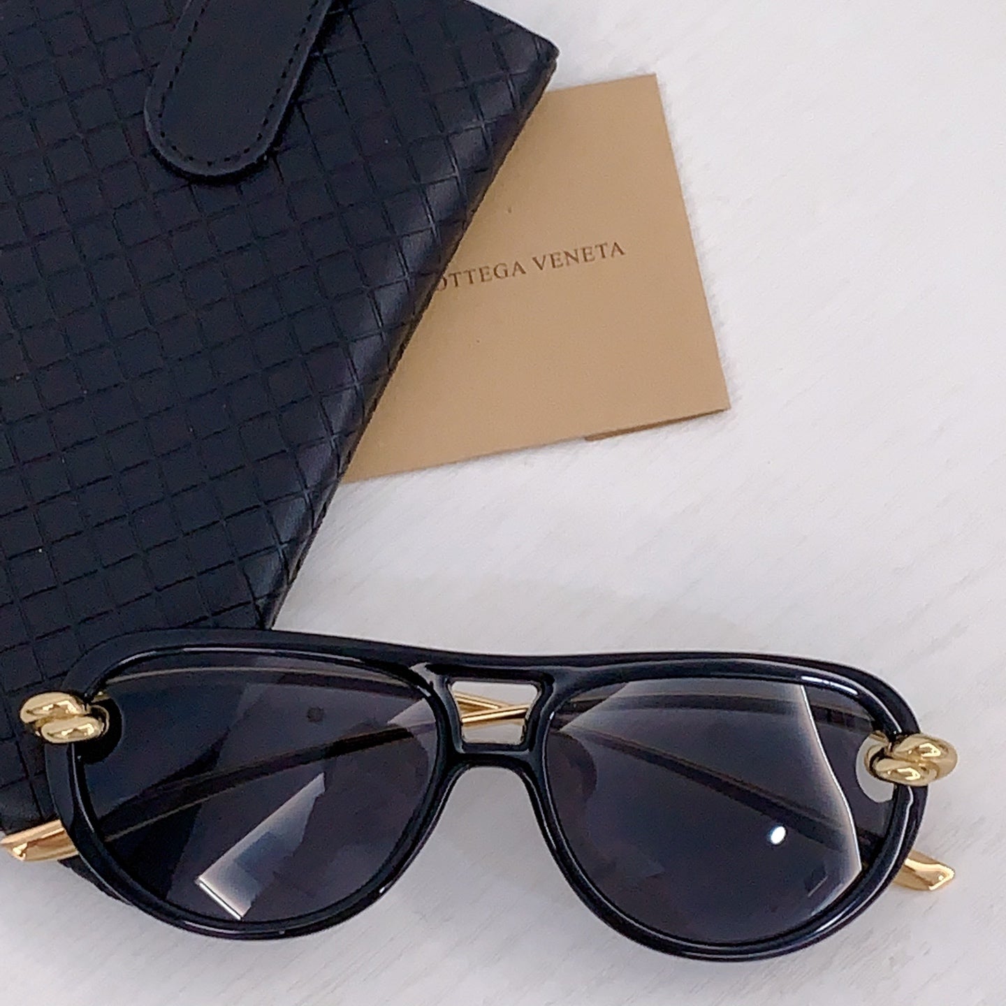 Black sunglasses with dark lenses and silver-tone accents, cat-eye frame
