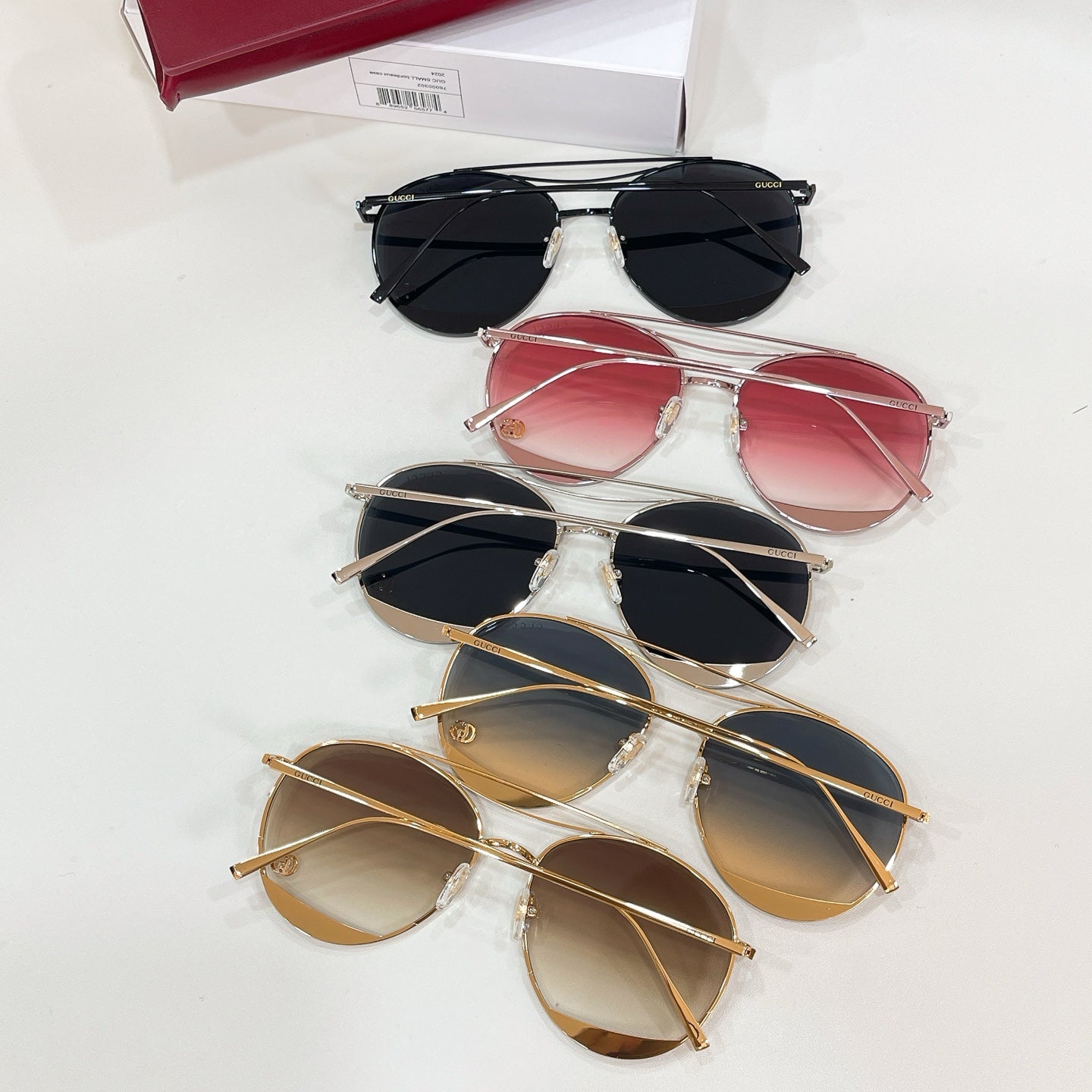 Set of five Gucci sunglasses with red, pink, black, and gold frames