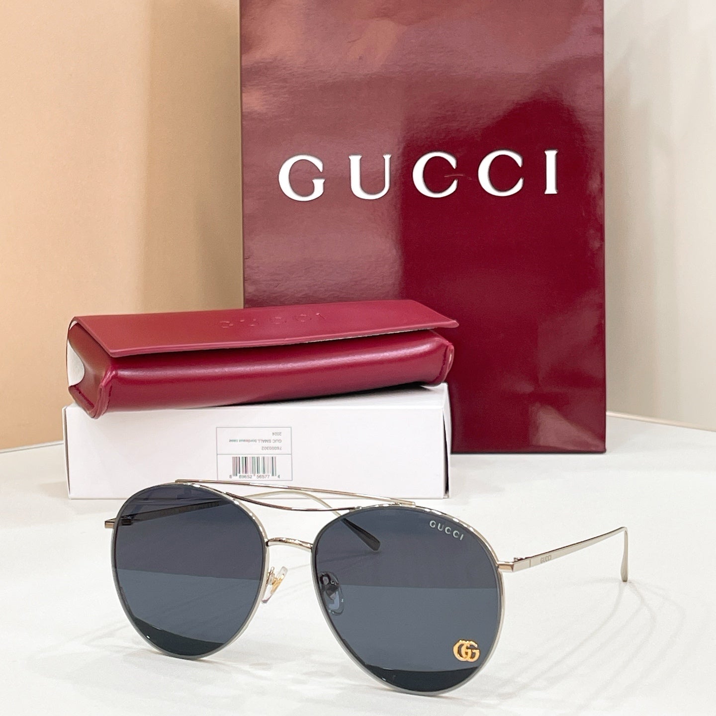 Round Gucci sunglasses, dark lenses on gold metal frame with logo at temple