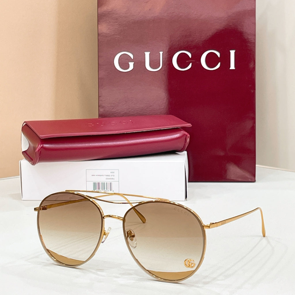 Round Gucci sunglasses, tan tinted lenses and gold metal frame, logo detail