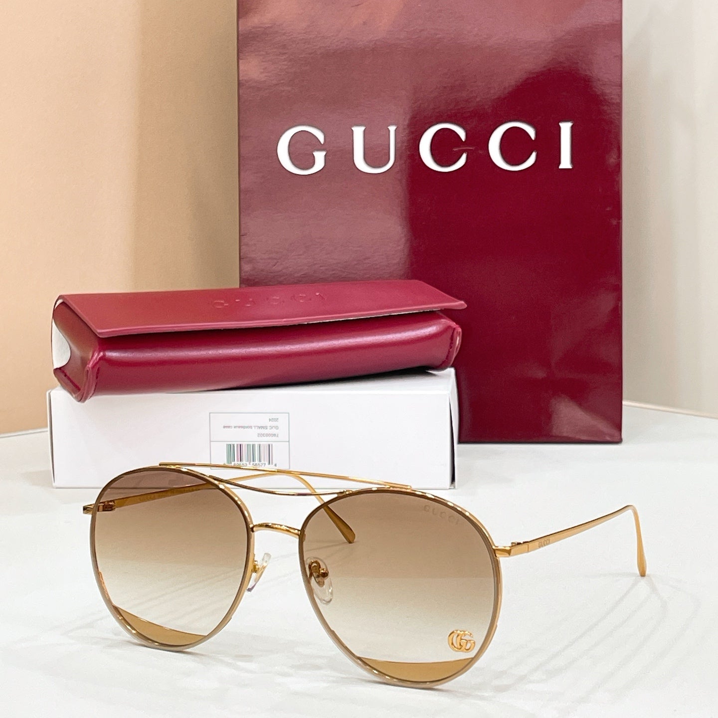 Round Gucci sunglasses, tan tinted lenses and gold metal frame, logo detail