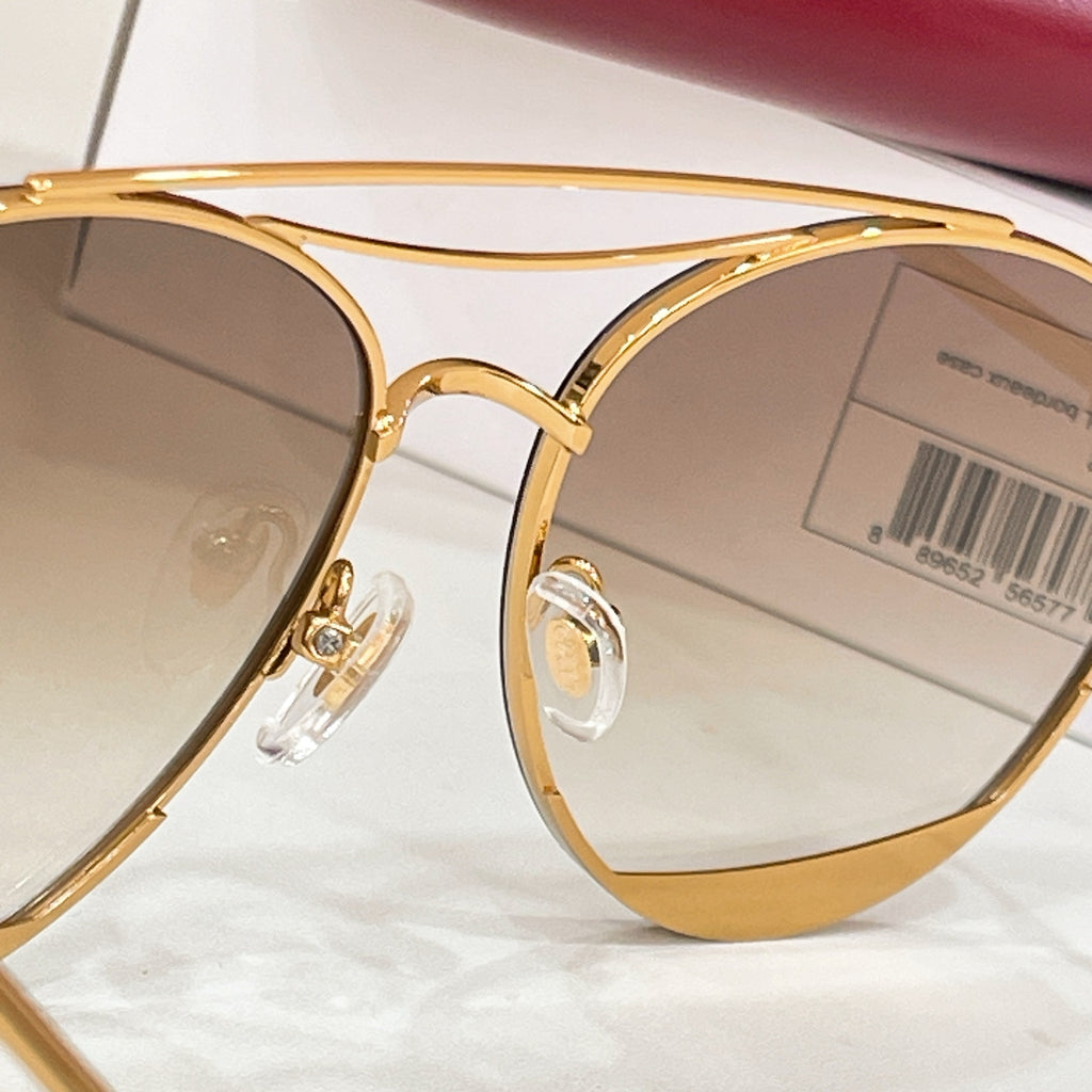 Gold Gucci sunglasses close-up, beige tinted lenses and metal bridge