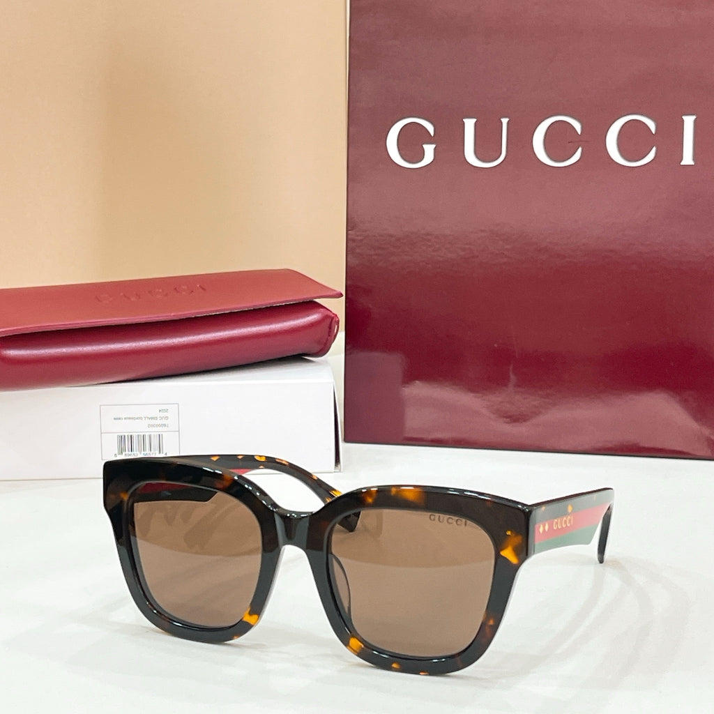 Brown tortoiseshell square eyeglass frames with tan-tinted lenses and Gucci logo.
