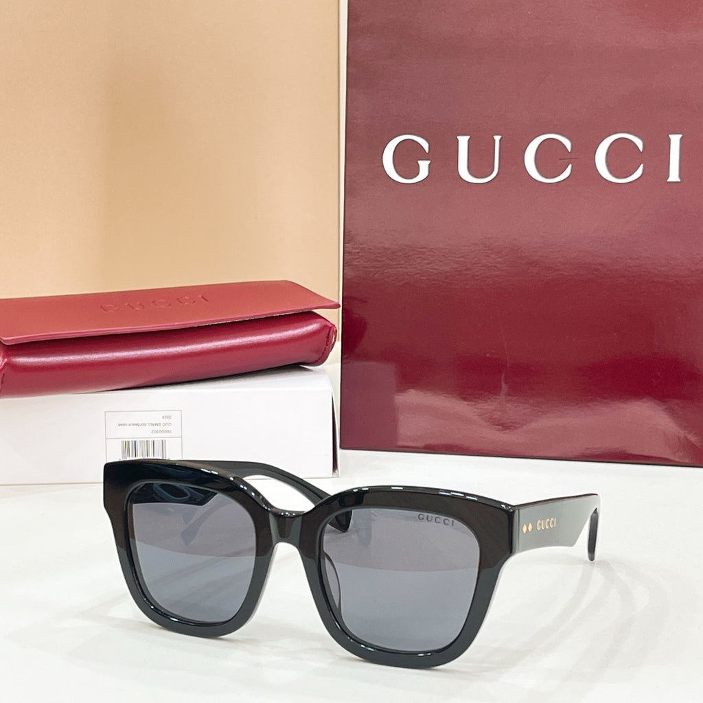 Black square eyeglass frames with clear lenses and Gucci logo temples.