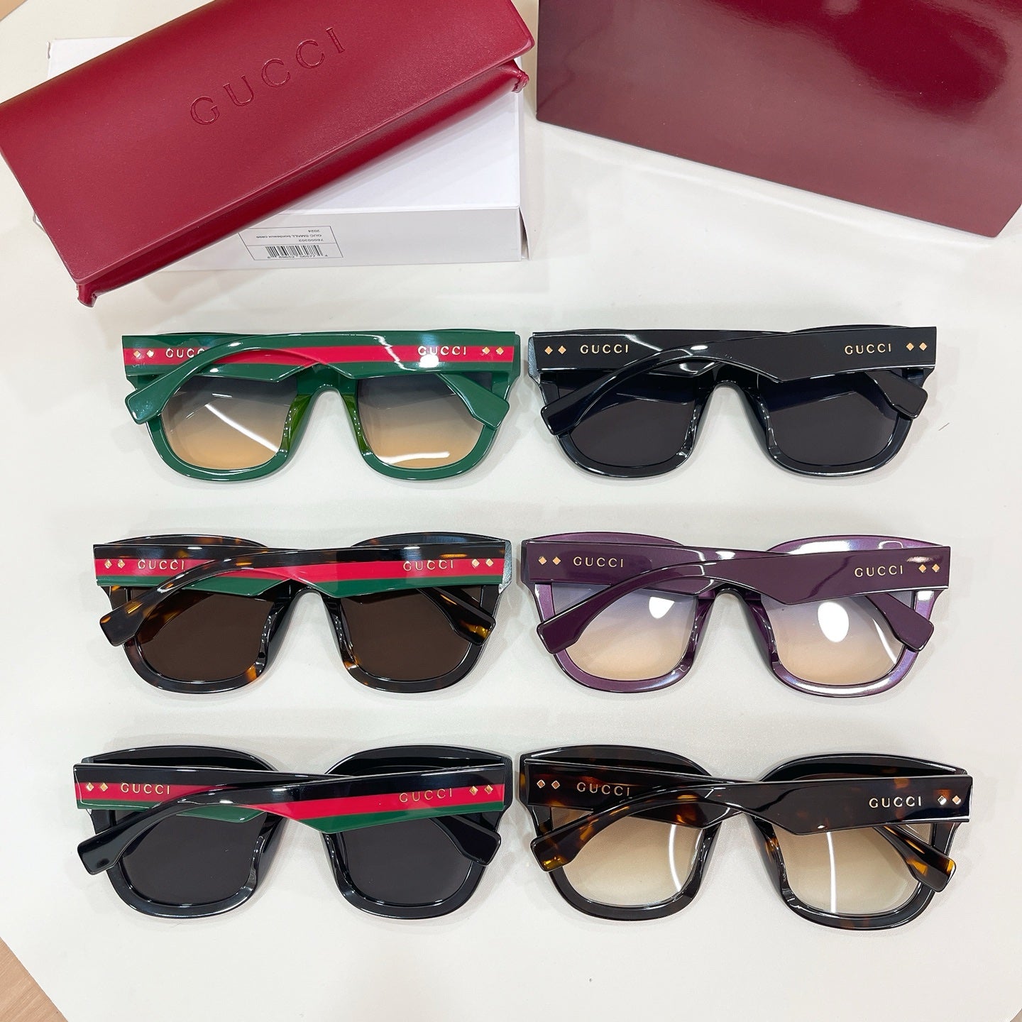 Set of Gucci sunglasses and eyeglasses with black, green, purple, and brown frames.