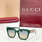 Green square eyeglass frames with clear lenses and Gucci logo temples.