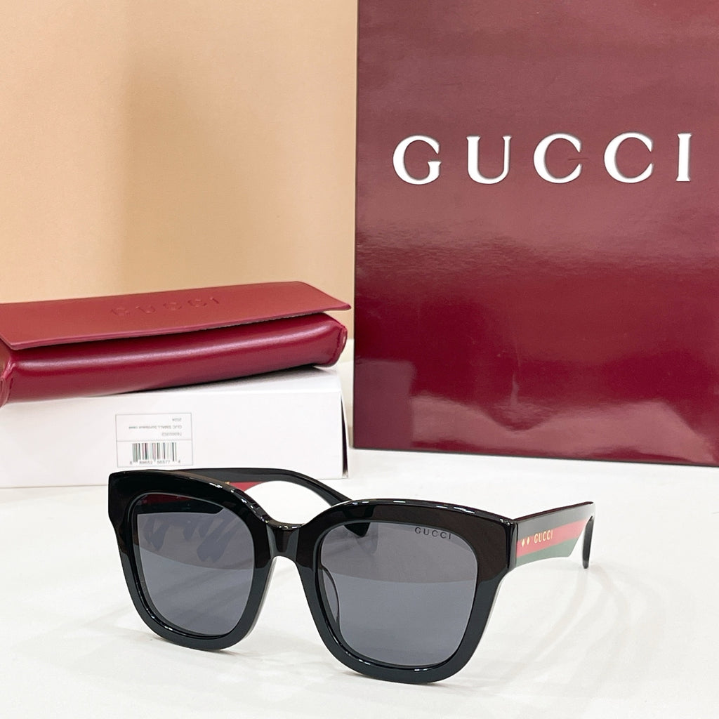 Black square eyeglass frames with gray-tinted lenses and Gucci logo temples.