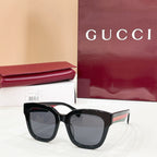 Black square eyeglass frames with gray-tinted lenses and Gucci logo temples.