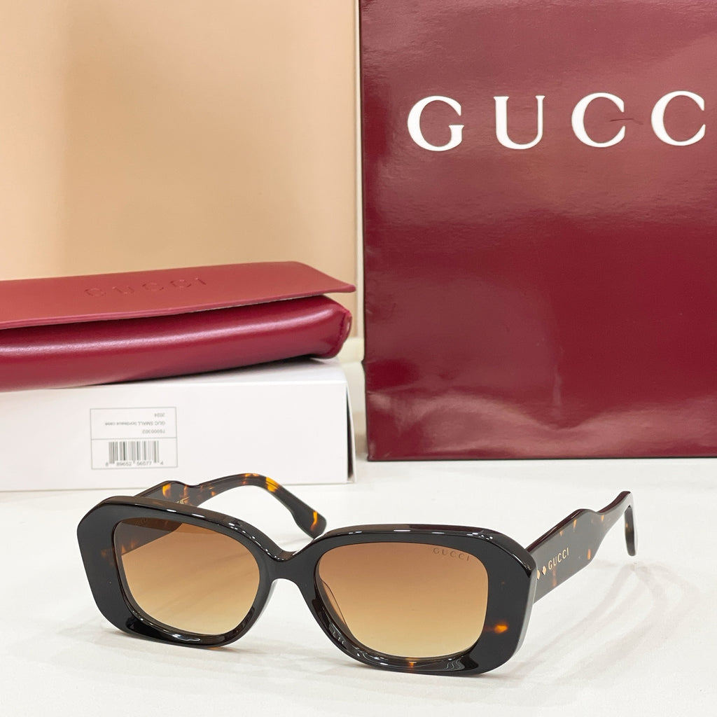 Gucci sunglasses, dark tortoiseshell cat-eye frames with amber-tinted lenses