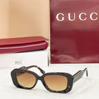 Gucci sunglasses, dark tortoiseshell cat-eye frames with amber-tinted lenses