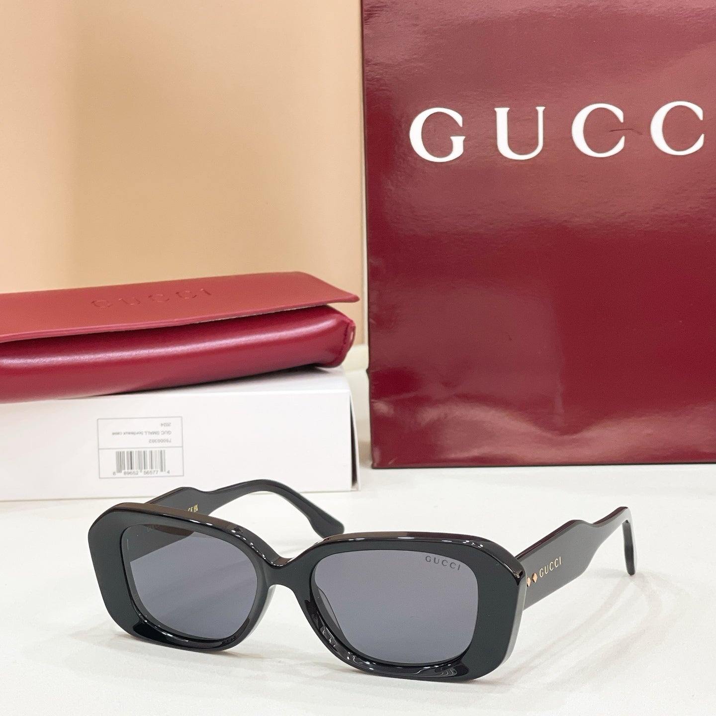 Gucci sunglasses, black cat-eye frames with gray-tinted lenses