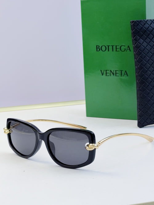 Black cat-eye eyeglasses with dark lenses and gold-tone temples