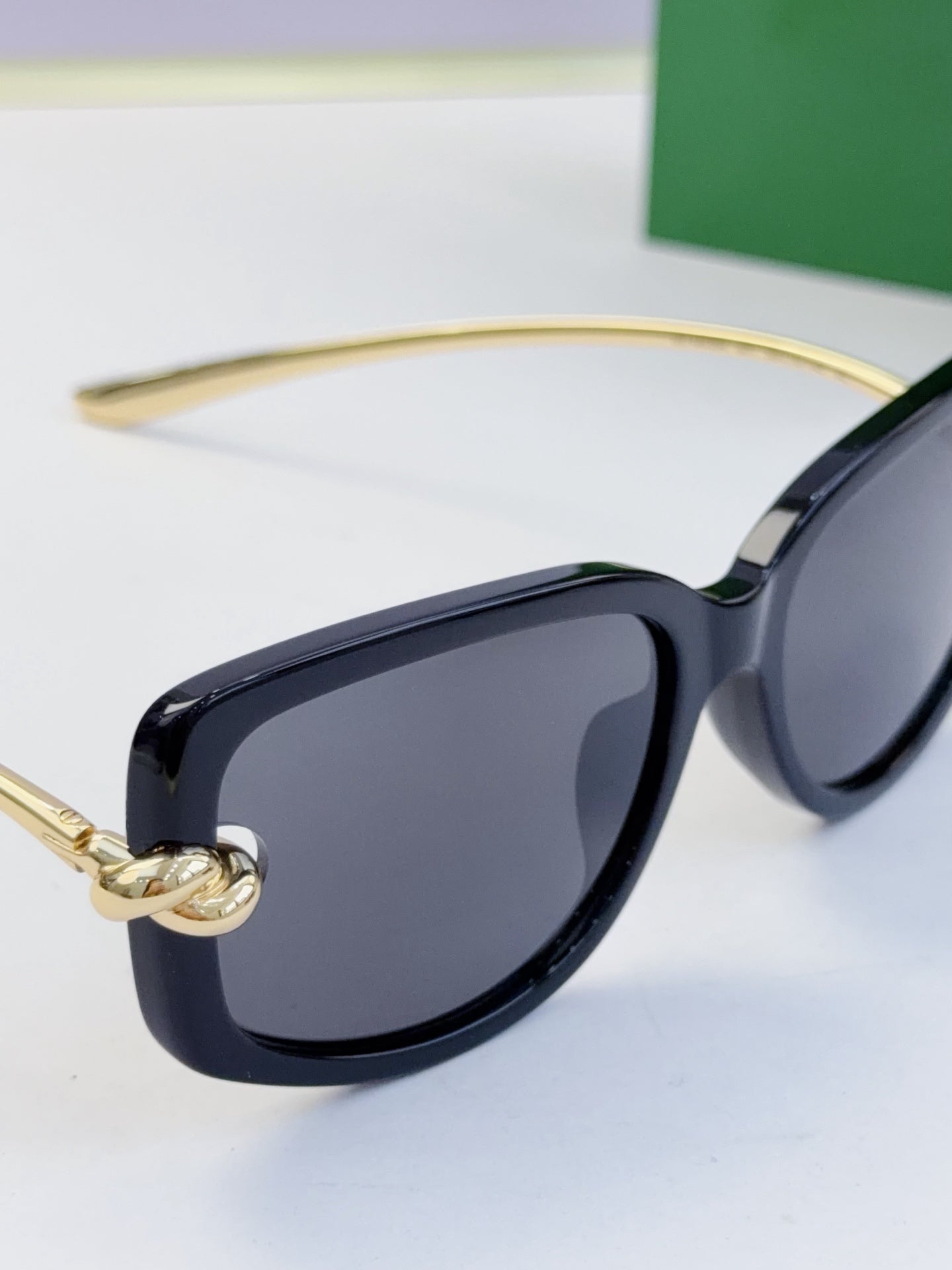 Navy-blue square eyeglasses with dark lenses and gold-tone hinge detail