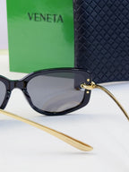 Black oversized eyeglasses with dark lenses and gold-tone temples