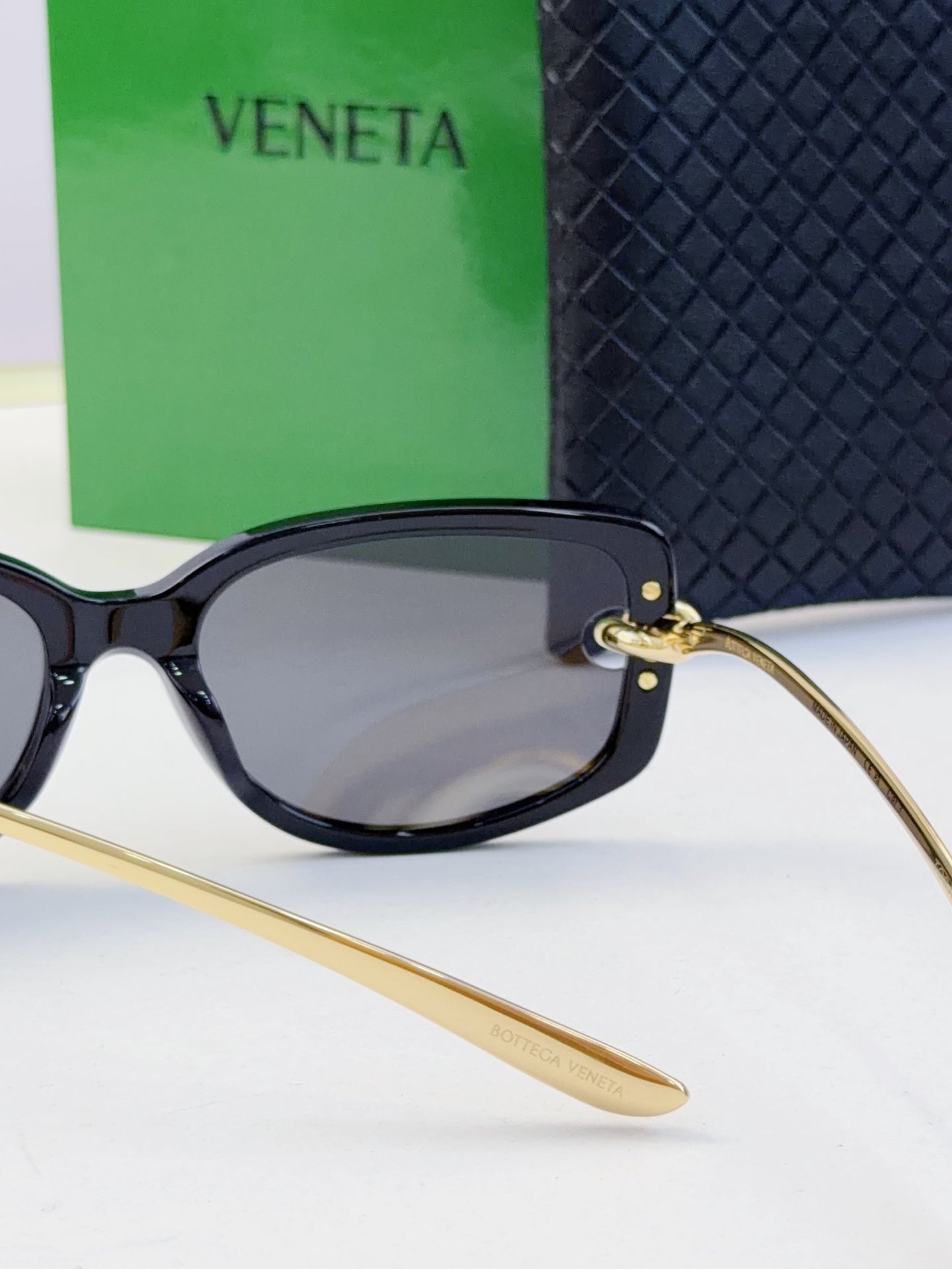 Black oversized eyeglasses with dark lenses and gold-tone temples
