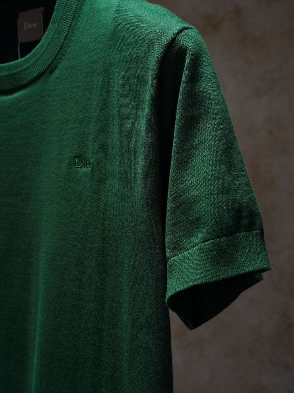 Green Dior crewneck knit top, close-up of sleeve and collar