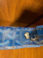 Blue patterned strap and logo tab with gold-tone clasp on flap
