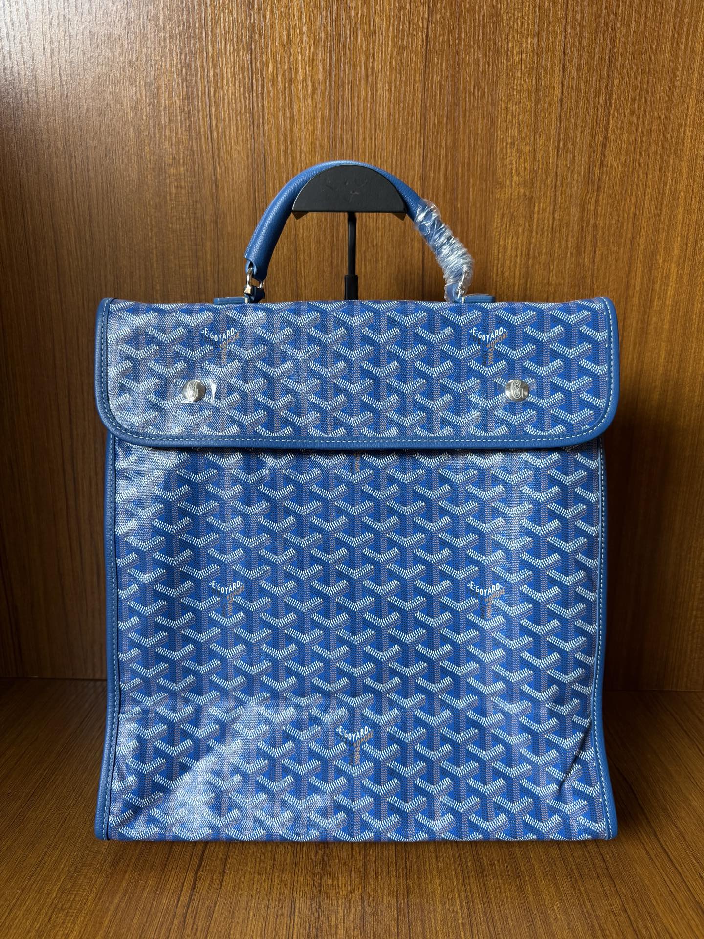 Blue patterned handbag with flap, top handles, and gold-tone hardware