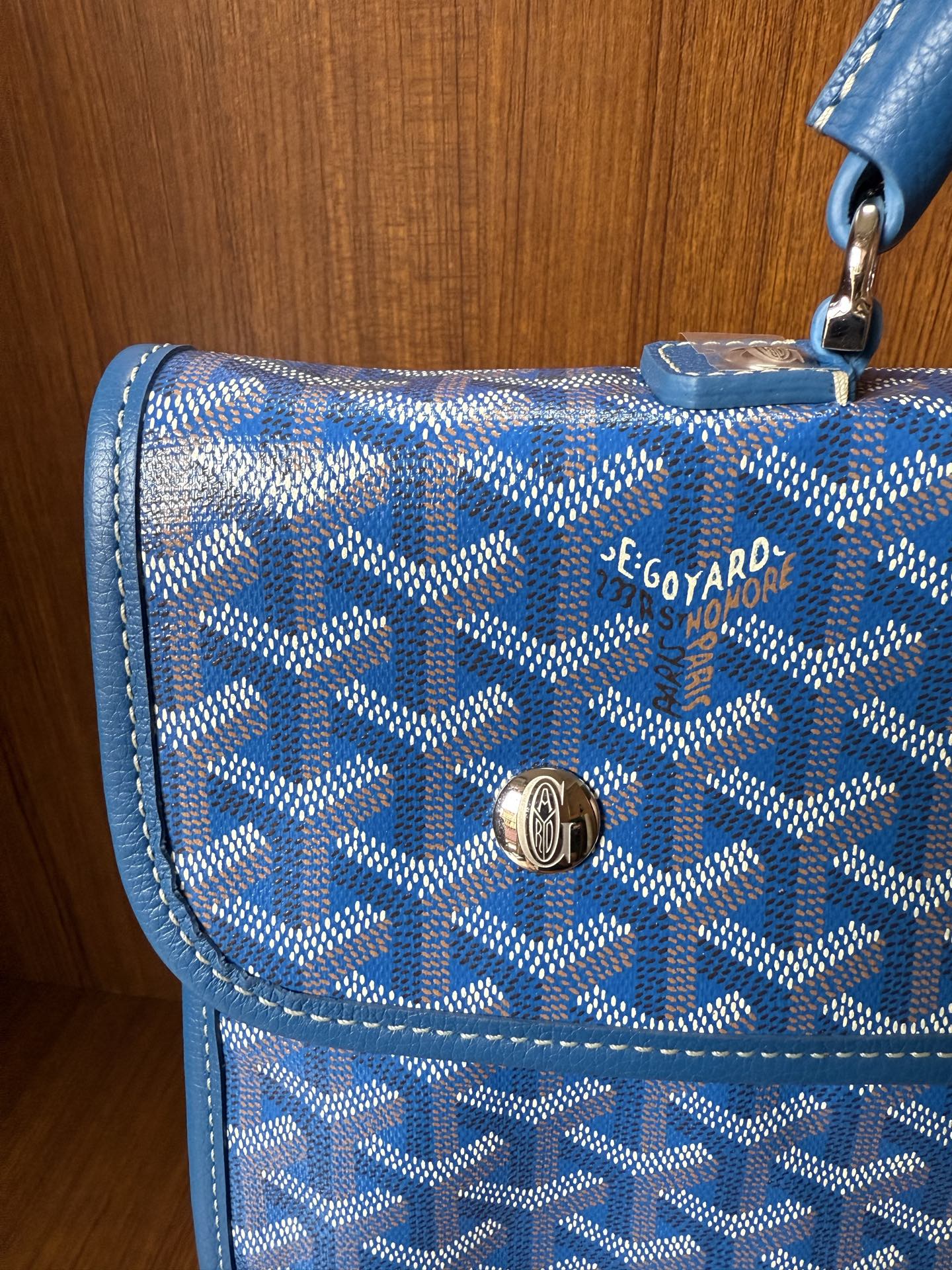 Blue patterned flap with logo plaque and gold-tone clasp, stitched trim