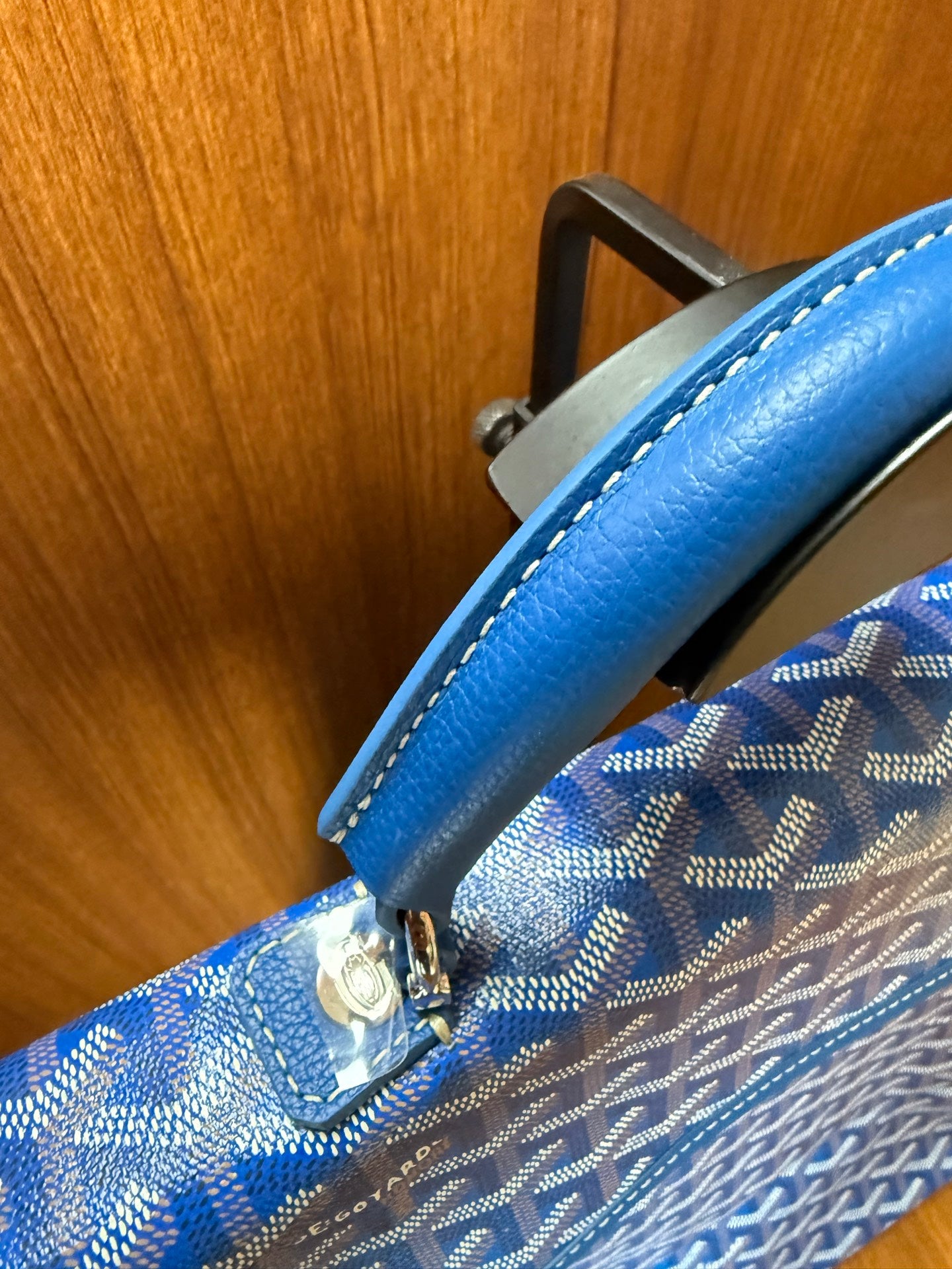 Blue patterned shoulder strap attachment with gold hardware and contrast stitching