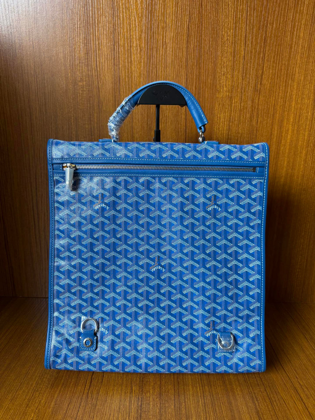 Blue patterned handbag with front hardware accents and top handles, gold-tone