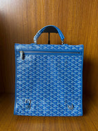 Blue patterned handbag with front hardware accents and top handles, gold-tone