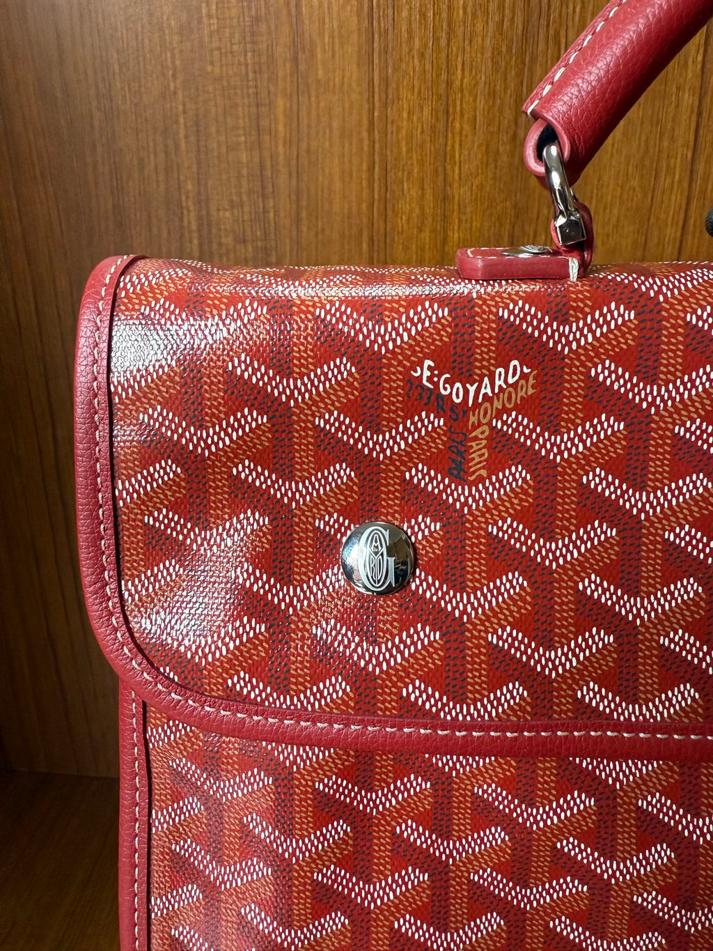 Red Goyard patterned handbag with front flap pocket and metal clasp hardware