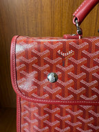 Red Goyard patterned handbag with front flap pocket and metal clasp hardware