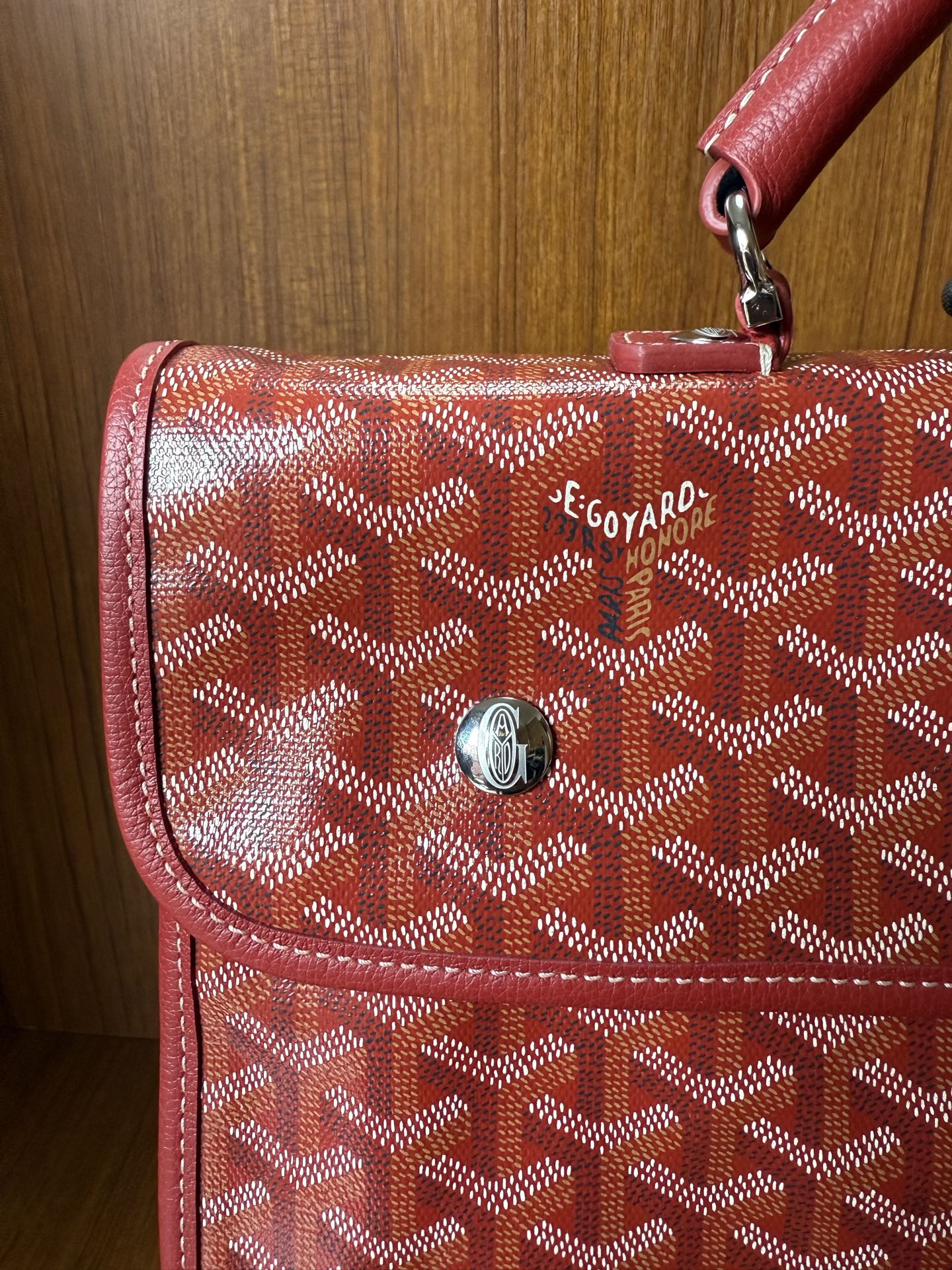 Red Goyard patterned handbag with front flap pocket and metal clasp hardware