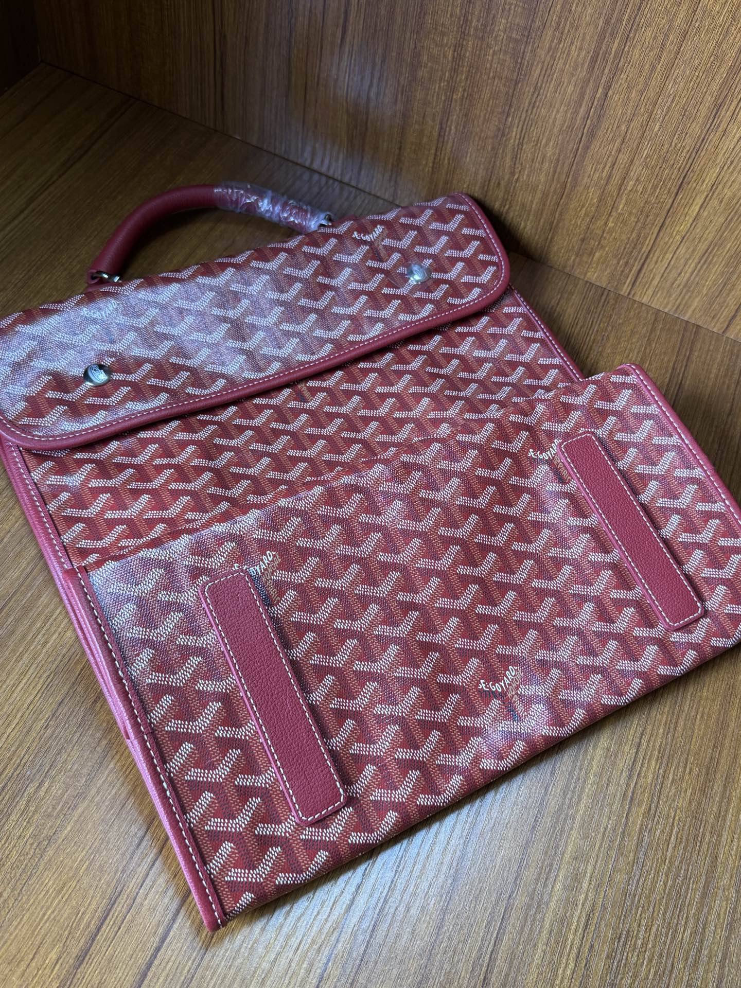 Red Goyard patterned handbag with exterior pocket and slim strap loop