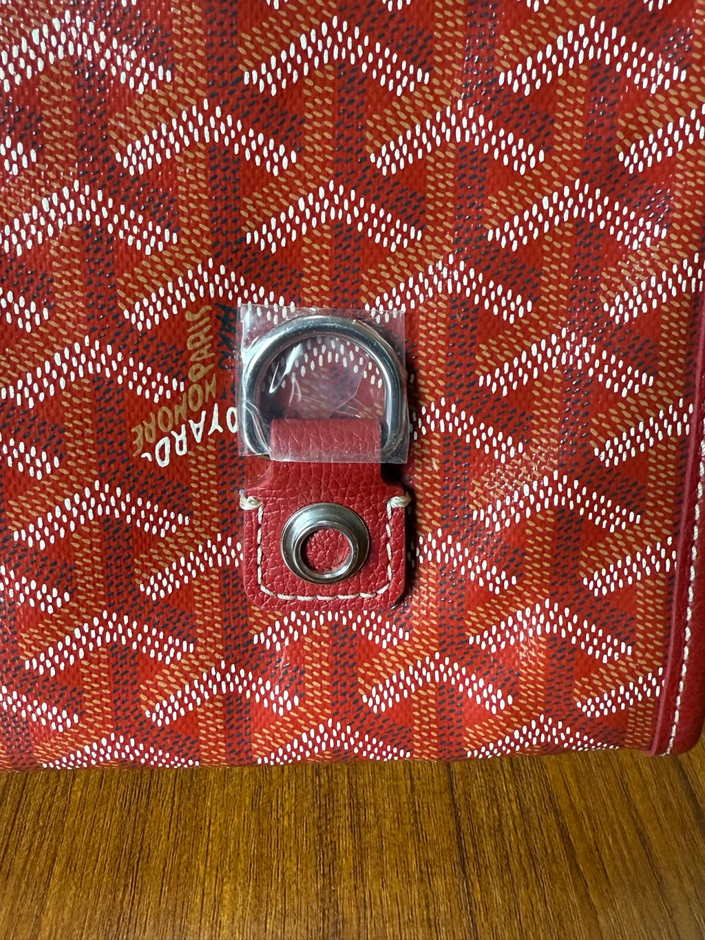 Red Goyard patterned handbag close-up of front clasp hardware