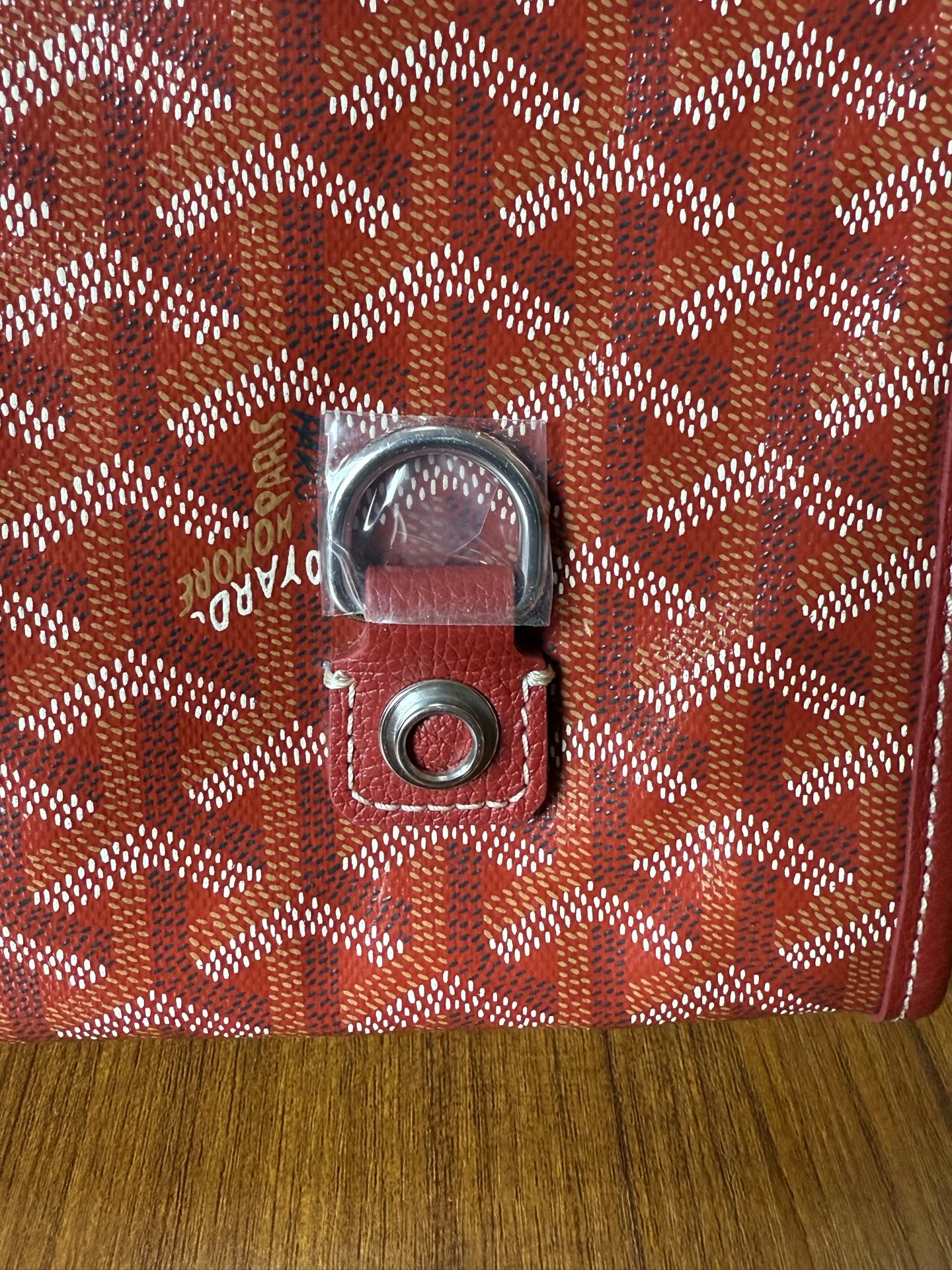 Red Goyard patterned handbag close-up of front clasp hardware