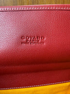Red Goyard bag leather stamp on textured surface with stitched edge