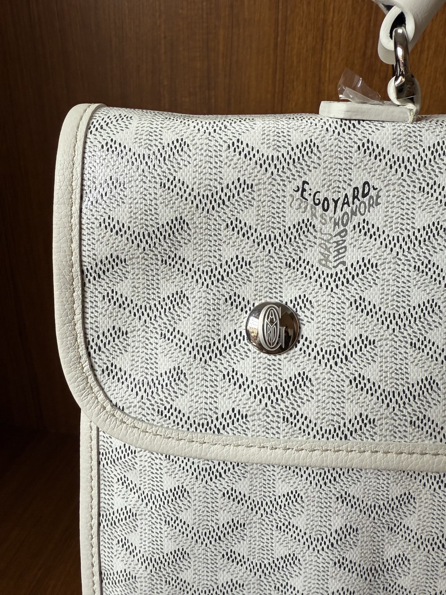 Designer monogram flap bag in light gray with metal clasp and stitched trim