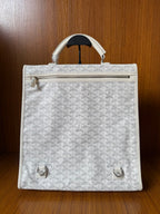 Designer monogram tote bag in light gray with zipper top and front hardware