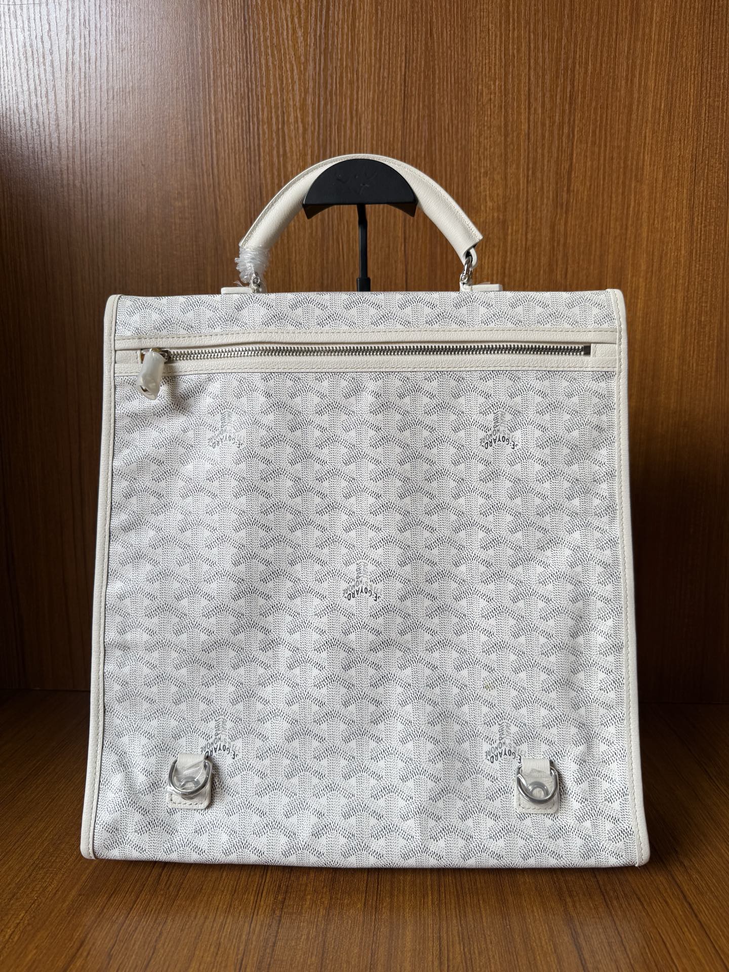 Designer monogram tote bag in light gray with zipper top and front hardware