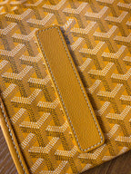 Yellow leather trim on patterned tote bag with stitched strap tab