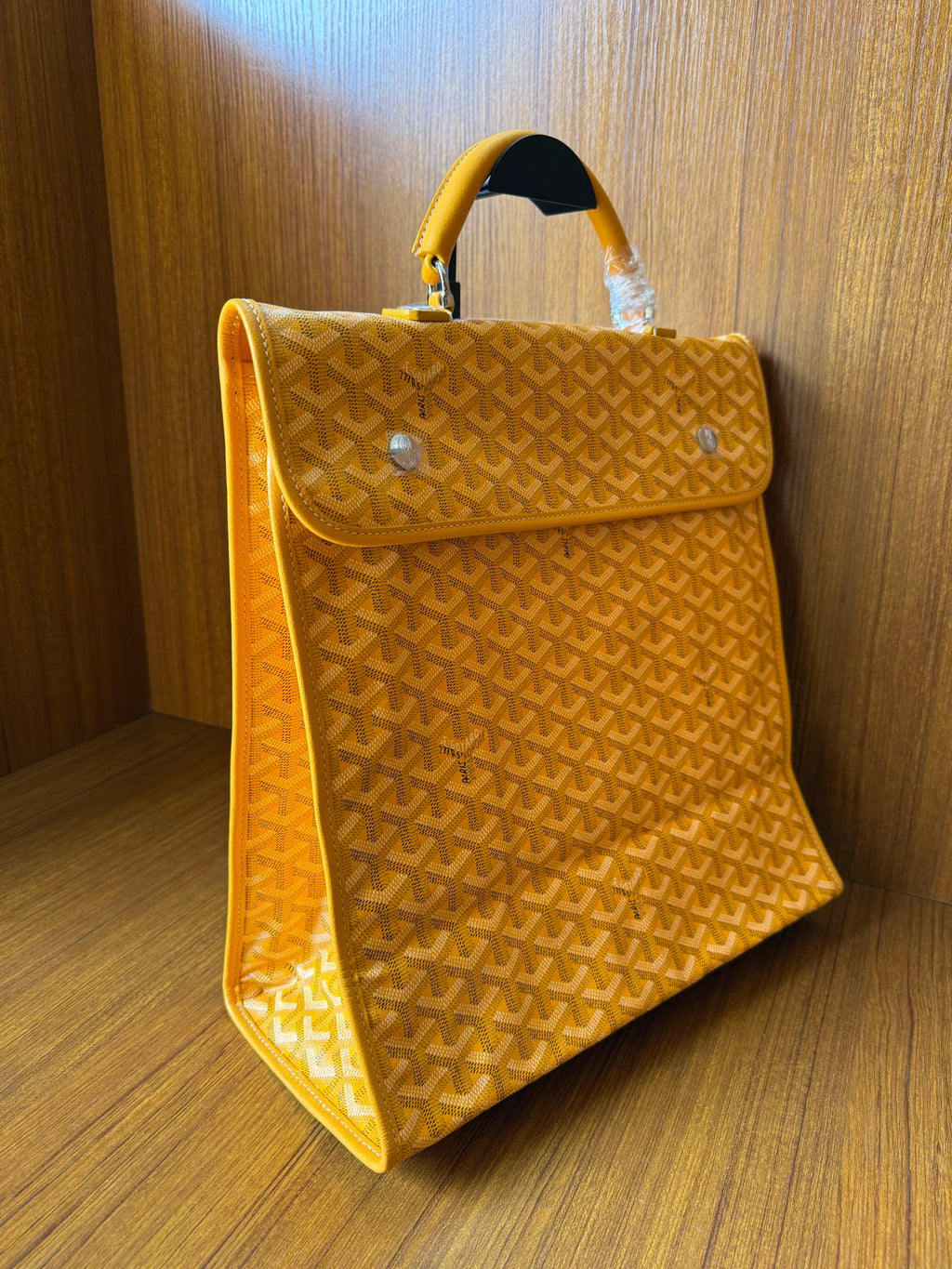 Yellow patterned tote bag with flap and side profile with top handle