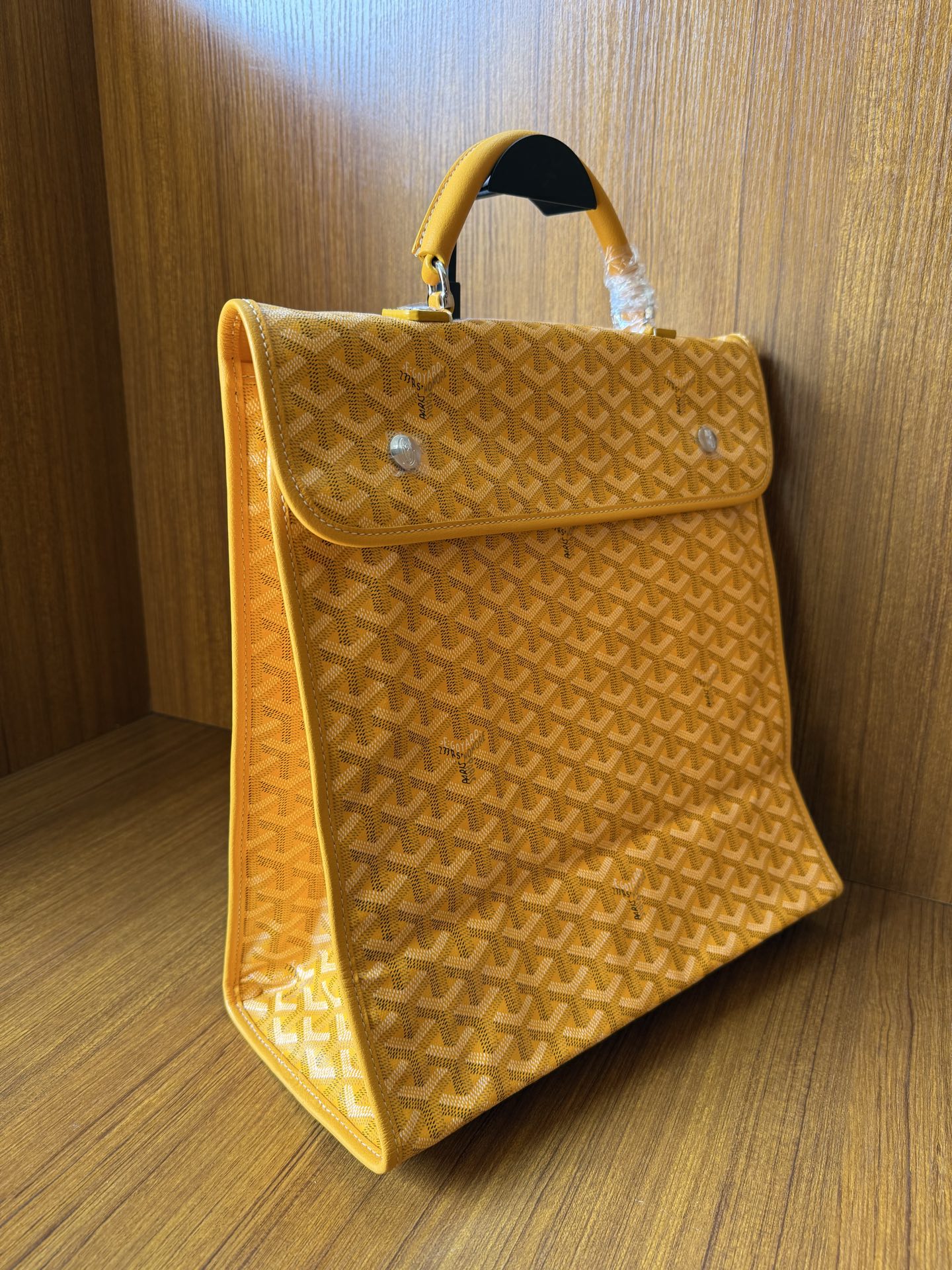 Yellow patterned tote bag with flap and side profile with top handle