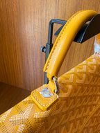Yellow patterned tote bag corner with leather strap and metal attachment ring