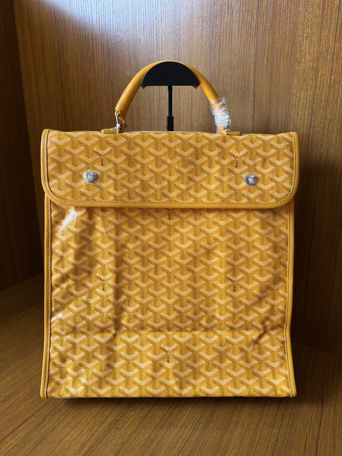 Yellow patterned tote bag with flap, top handle, and metal snap buttons