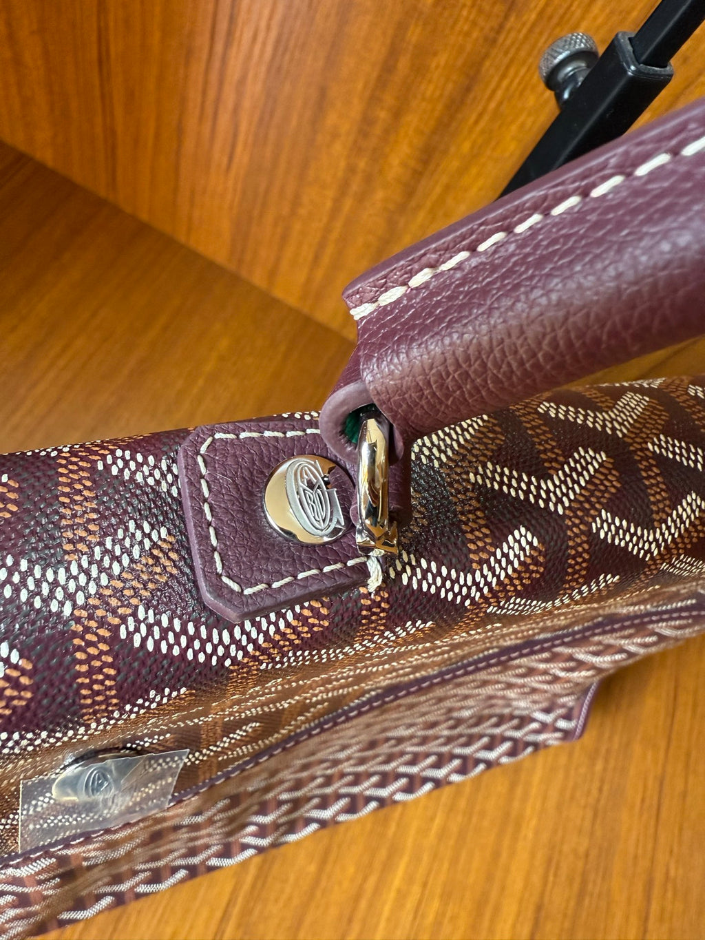 Goyard monogram tote bag corner with gold-tone clasp and stitched leather trim
