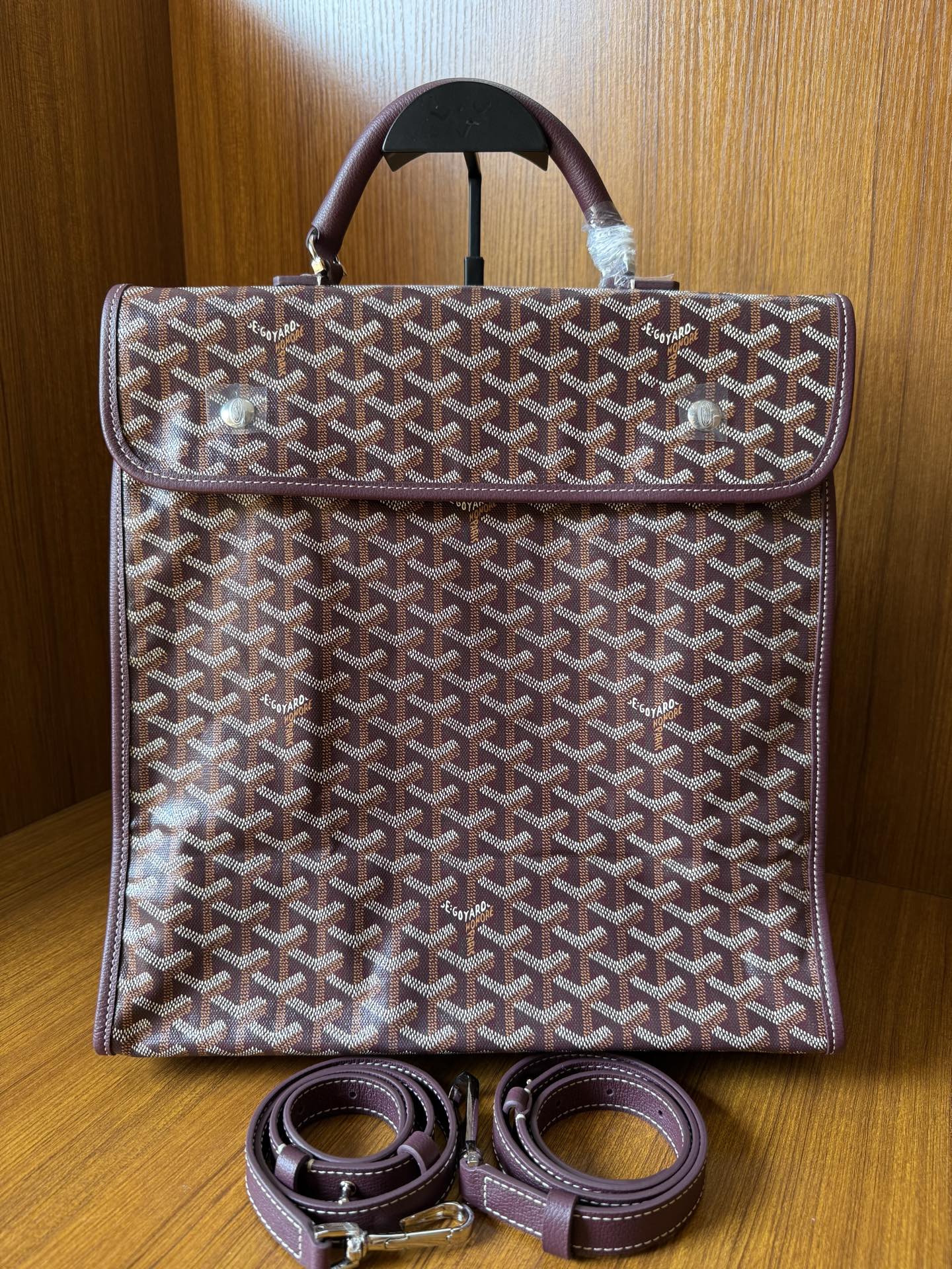 Goyard patterned tote bag with top handle and two leather straps beneath, front view