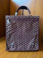 Goyard monogram tote bag with top handle, flap closure, and two front snap tabs
