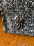 Gray patterned handbag clasp with round metal lock on the front flap