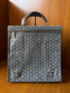 Gray patterned handbag with front zipper, flap, and metal turn-lock hardware