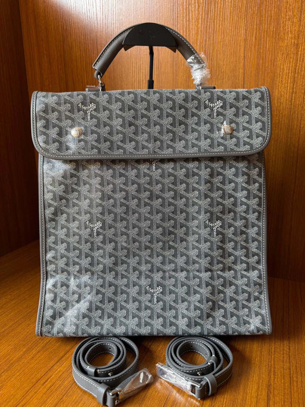 Gray patterned handbag with matching strap set, front flap, and top handles
