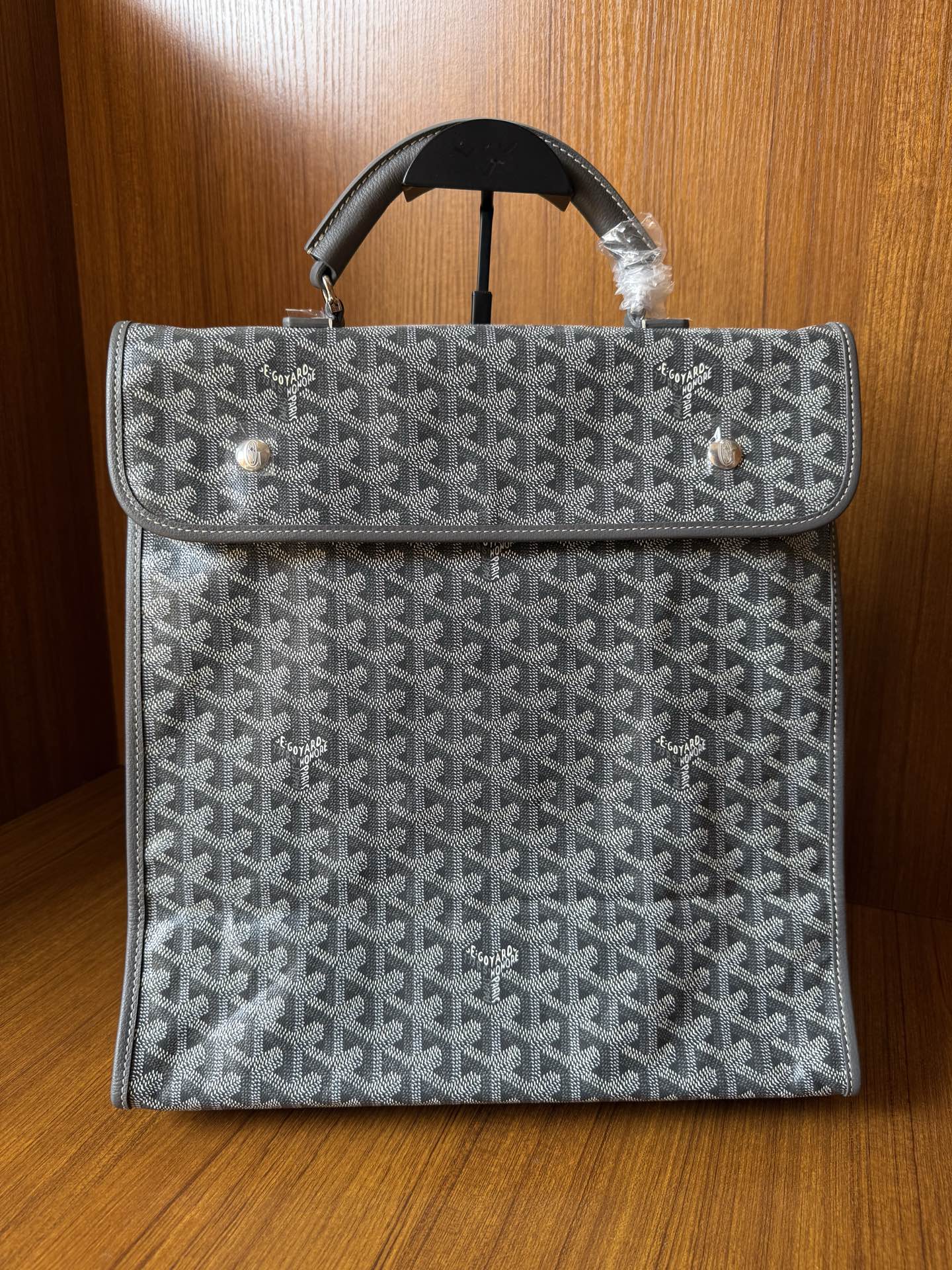 Gray patterned Goyard-style handbag with flap and black top handles