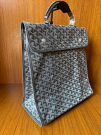 Structured gray patterned handbag with top handle and long side flap